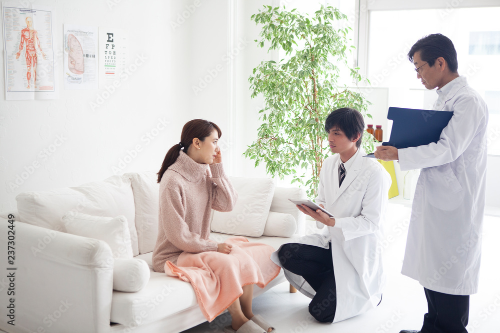 医者に症状を伝え診察を待っている女性 医者に症状を伝え診察を待っている女性