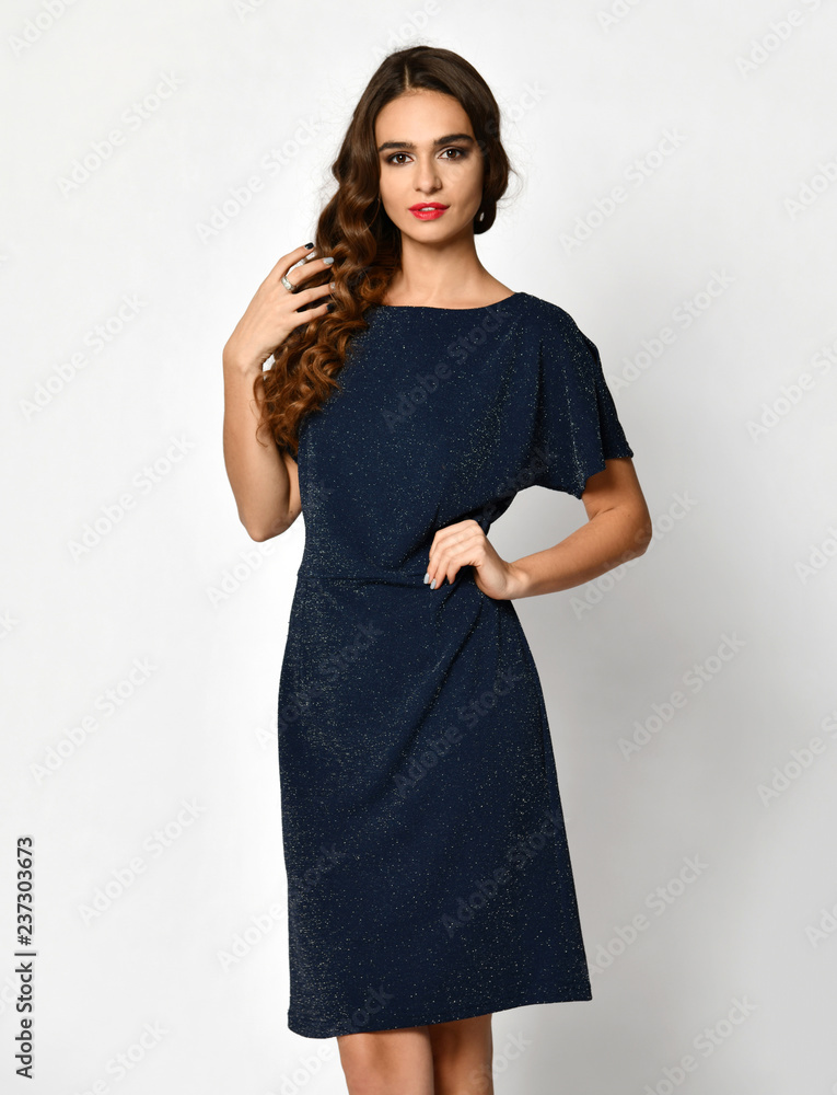 Young beautiful woman posing in new blue fashion winter dress on a white Young beautiful woman posing in new blue fashion winter dress on a white