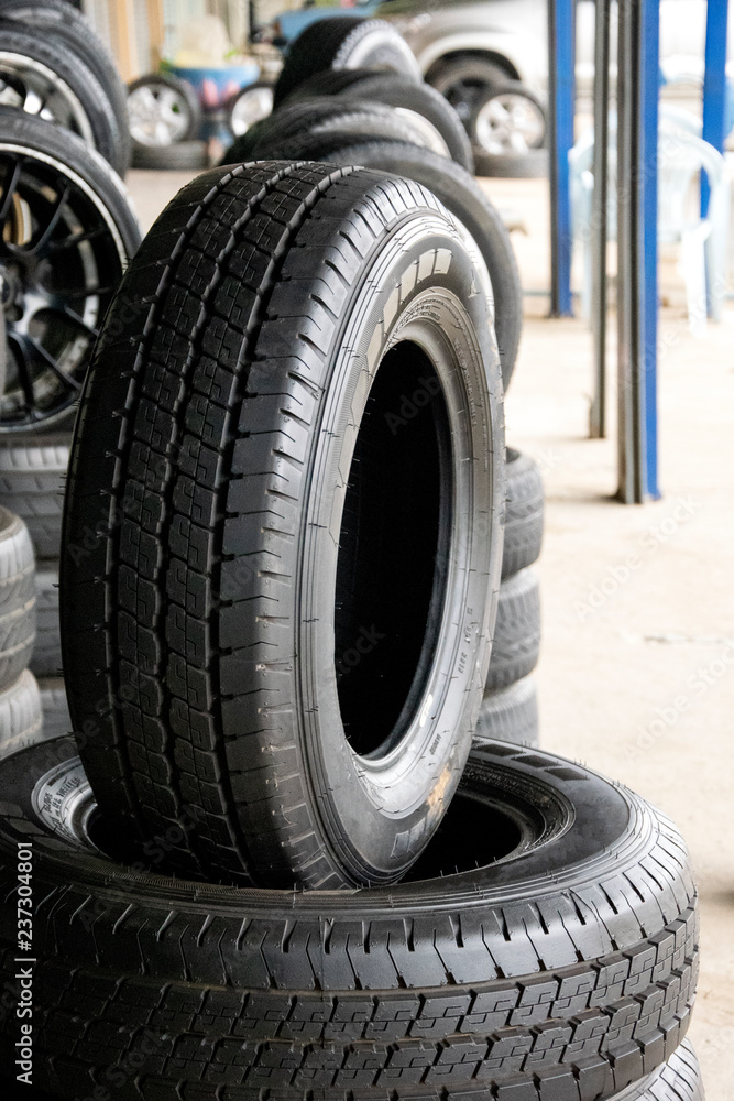 Set of new modern tires in shop. Sale a tire in shop in the background. Set of new modern tires in shop. Sale a tire in shop in the background.