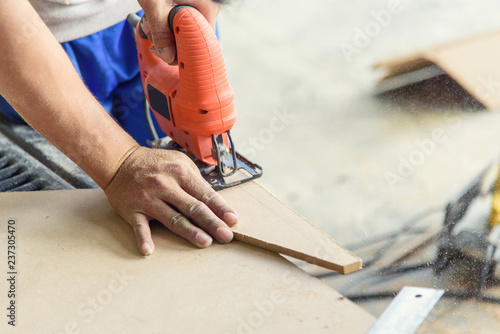 Worker use jigsaw tool saw wood plate