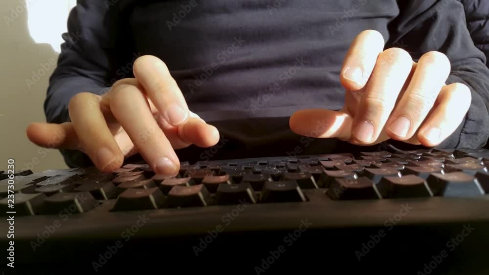 employee writes to the keyboard in an office employee writes to the keyboard in an office