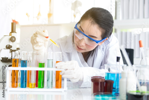 Scientist beautiful woman working putting medical chemicals sample in test tube at lab