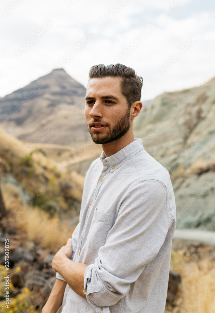 Lifestyle portrait of young adult male barefoot in high desert canyon area of eastern Oregon northwest USA Lifestyle portrait of young adult male barefoot in high desert canyon area of eastern Oregon northwest USA