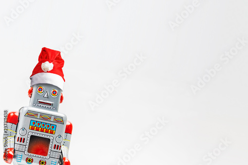 Vintage robot retro classic toy with Christmas hat on white background photo