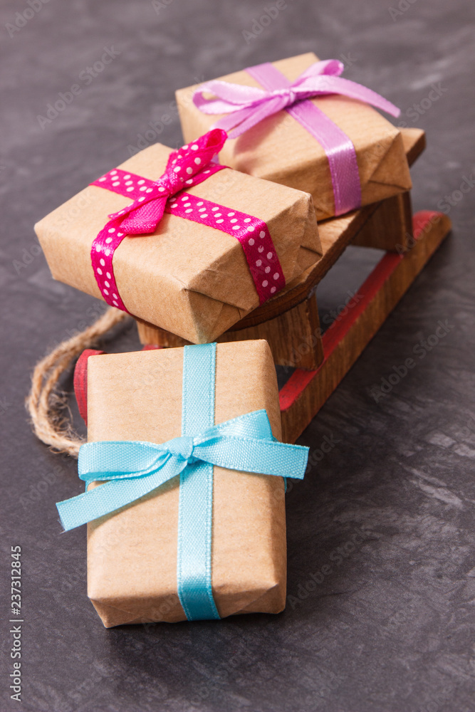 Wrapped gift for Christmas or other different occasions and wooden sled Wrapped gift for Christmas or other different occasions and wooden sled