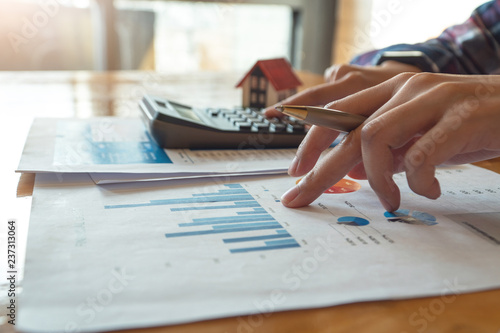 Woman press the calculator to calculating financial chart for investment to buying property