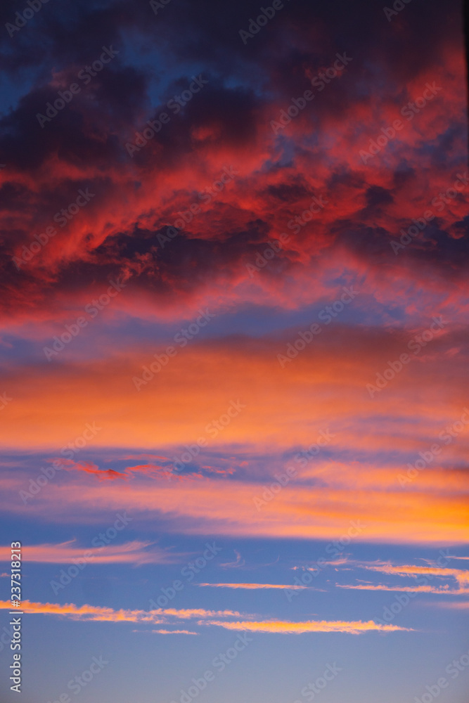 dramatic blue sky with orange clouds at sunset. vertical allignm