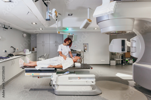 Smiling woman medic making radiotherapy treatment