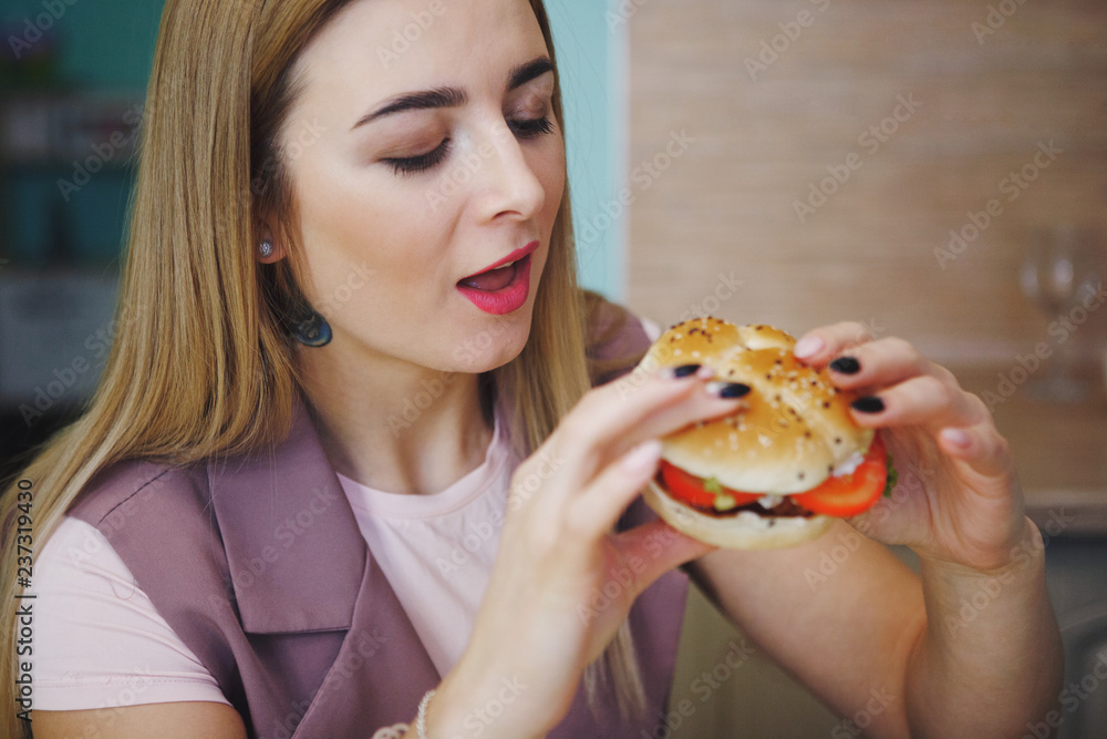 Pretty young woman with hamburger.