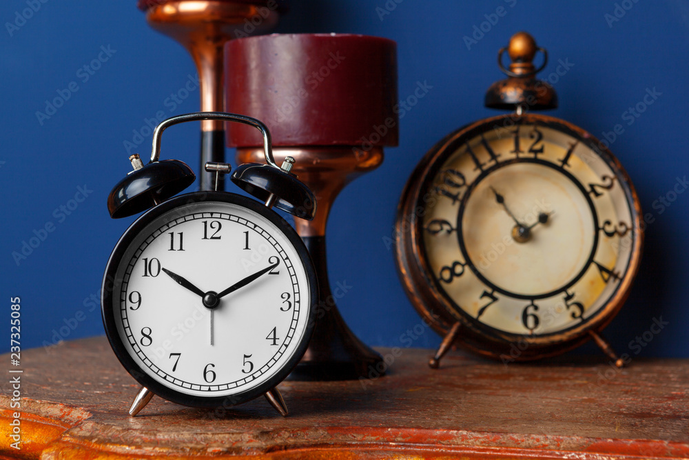 Different alarm clocks on table. Time change concept Different alarm clocks on table. Time change concept