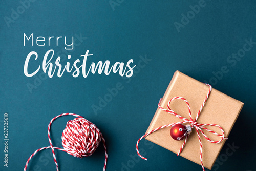 Christmas greeting card with gift box wrapped in kraft paper and tied with ca...