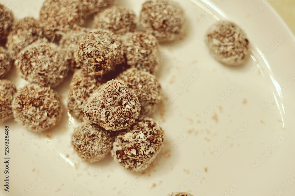 Close up of a white plate with homemade cocoa and coconut cookies bullets Close up of a white plate with homemade cocoa and coconut cookies bullets