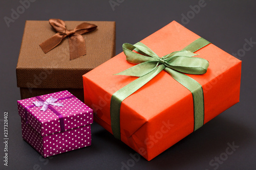 Gift boxes tied with ribbons on black background.