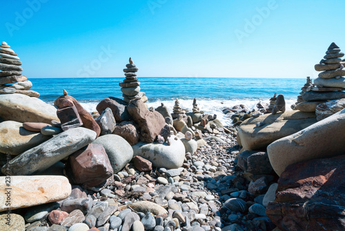 Pyramids of stones on the beach with the bright sun. Crimea.