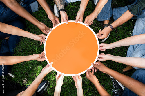 Group of people holding a round orange board photo