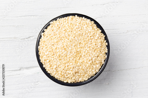 Sesame seeds on white wooden background