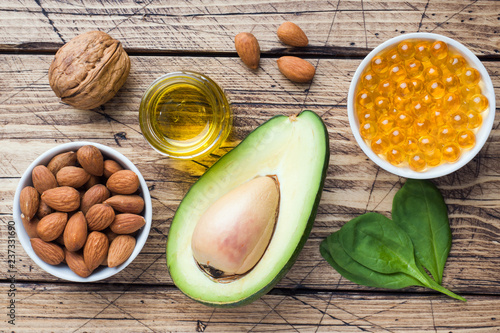 Concept Healthy food antioxidant products avocado, nuts and fish oil, grapefruit on wooden background. photo