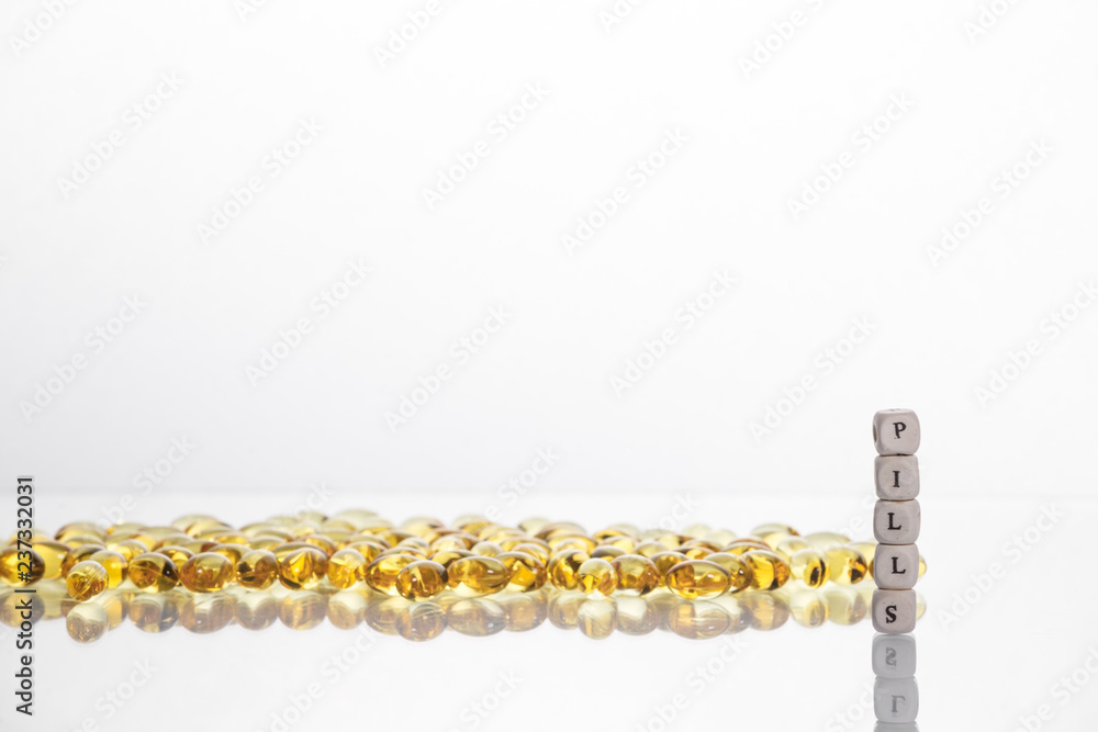 Word pills from the letters of cubes and Lecithin gel pills on light background. Word pills from the letters of cubes and Lecithin gel pills on light background.