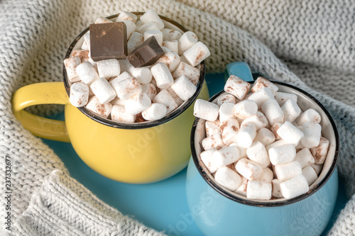 Mugs of hot chocolate with marshmallows on top and stick a Lollipop on a blue background. Cozy Christmas home holiday