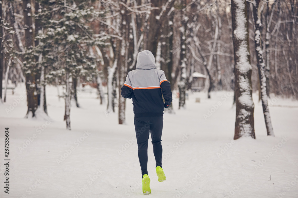 Man jogging in a cold winter snowy day outdoors. Man jogging in a cold winter snowy day outdoors.