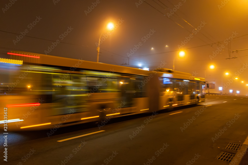 Motion blurred bus down the street in the evening. Motion blurred bus down the street in the evening.
