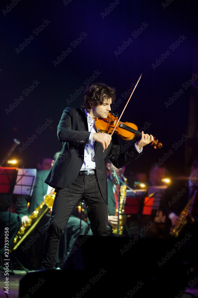 Fototapeta premium Musician violinist with a violin in his hands.