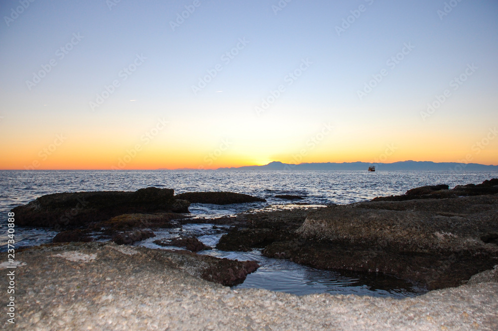 Beautiful twilight sky, coast with rocks in the Mediterranean Sea and the beach in the city of Side, Turkey