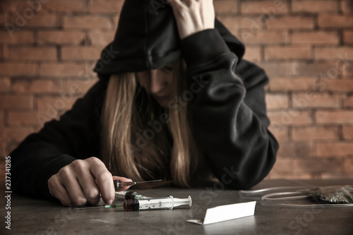 Female junkie with drugs at...
