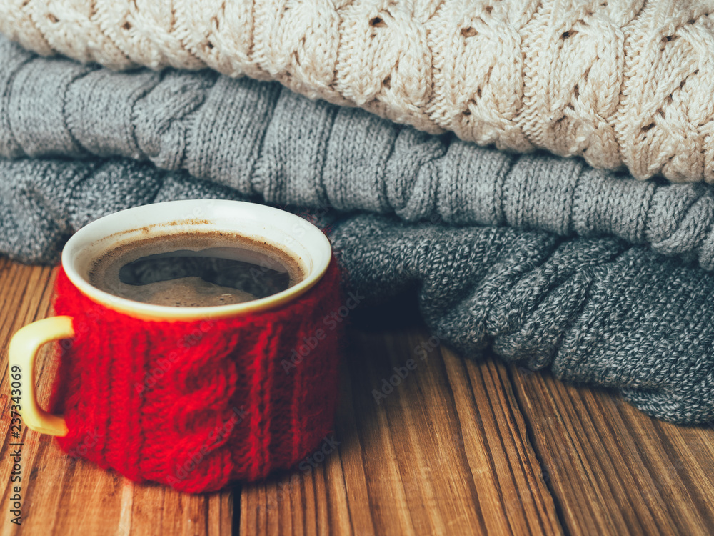 Coffee mug on the background of warm knitted sweaters Coffee mug on the background of warm knitted sweaters