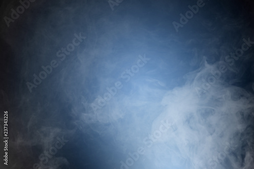 Smoke or mist or fog over dark background. Abstract background. © franz12