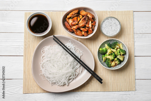 Flat lay composition with tasty chinese noodles on white wooden table