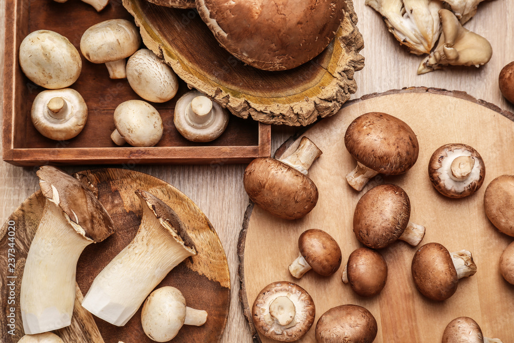 Fototapeta premium Variety of fresh raw mushrooms on wooden table