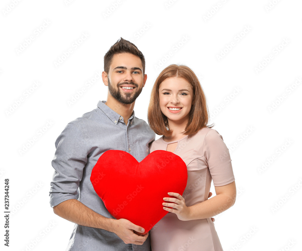 Loving young couple holding fabric heart on white background. Celebration of Saint Valentine's Day