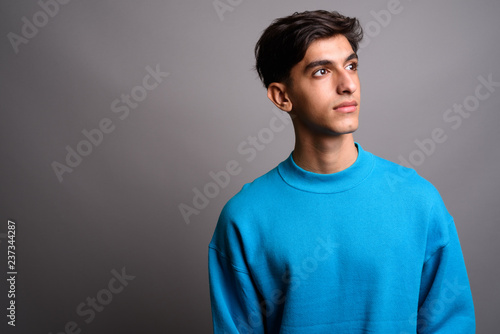 Portrait of young handsome Persian teenage boy thinking