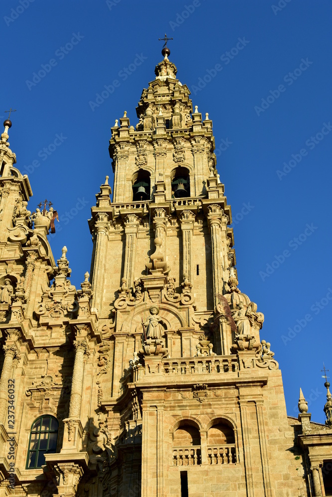 Cathedral with sunset light and clean stone. Obradoiro Square, Santiago de Compostela, Spain. Facade and tower details with statues.