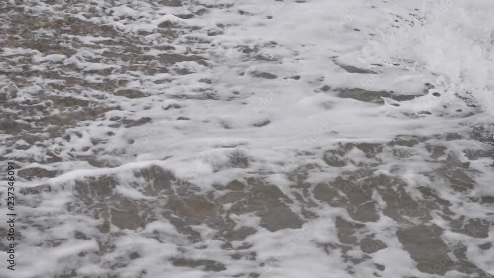 White sea foam moving shore pebble Slow motion video White sea foam moving shore pebble Slow motion video