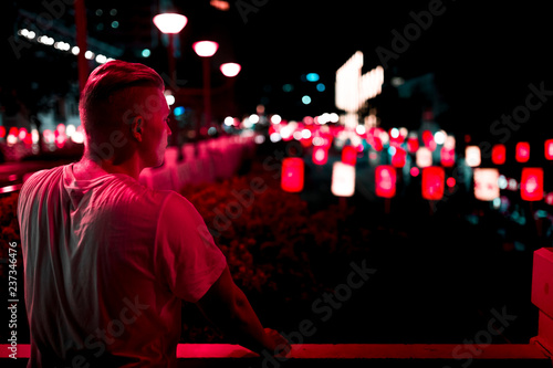 Mann vor Neon Reklame bei Nacht
