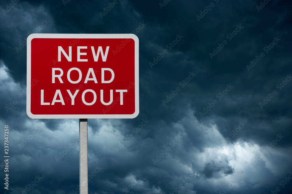 RED NEW ROAD LAYOUT WARNING SIGN WITH BLUE STORMY SKY AND CLOUDS IN BACKGROUND RED NEW ROAD LAYOUT WARNING SIGN WITH BLUE STORMY SKY AND CLOUDS IN BACKGROUND