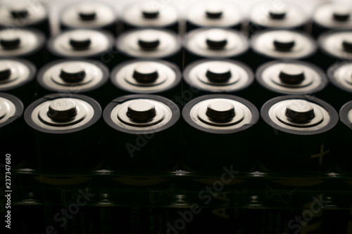Closeup of pile of used alkaline batteries. Close up colorful rows of selection of AA batteries energy abstract background of colorful batteries. 