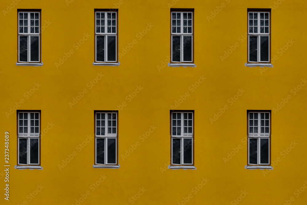 Closeup photo of bright yellow building with eight windows, seamless tiling texture