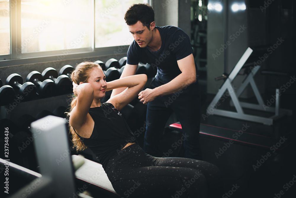 Obraz premium Beautiful woman is exercising and fitness. The trainer gives instructions on how to exercise in the gym.