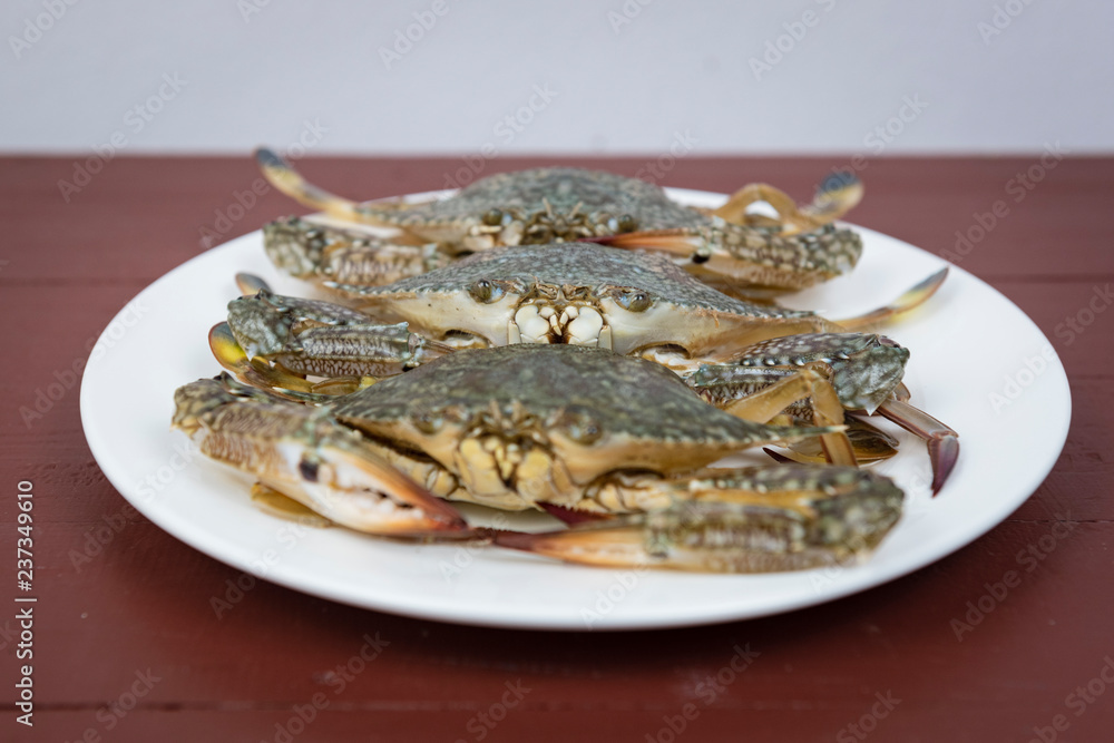 blue crabs on plate, on a wooden background blue crabs on plate, on a wooden background