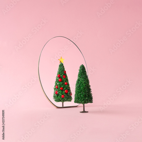 Christmas tree with mirror on pastel pink background. Minimal New Year decoration concept. photo