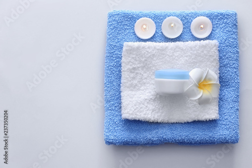 Beautiful spa composition with burning candles and towels on grey background