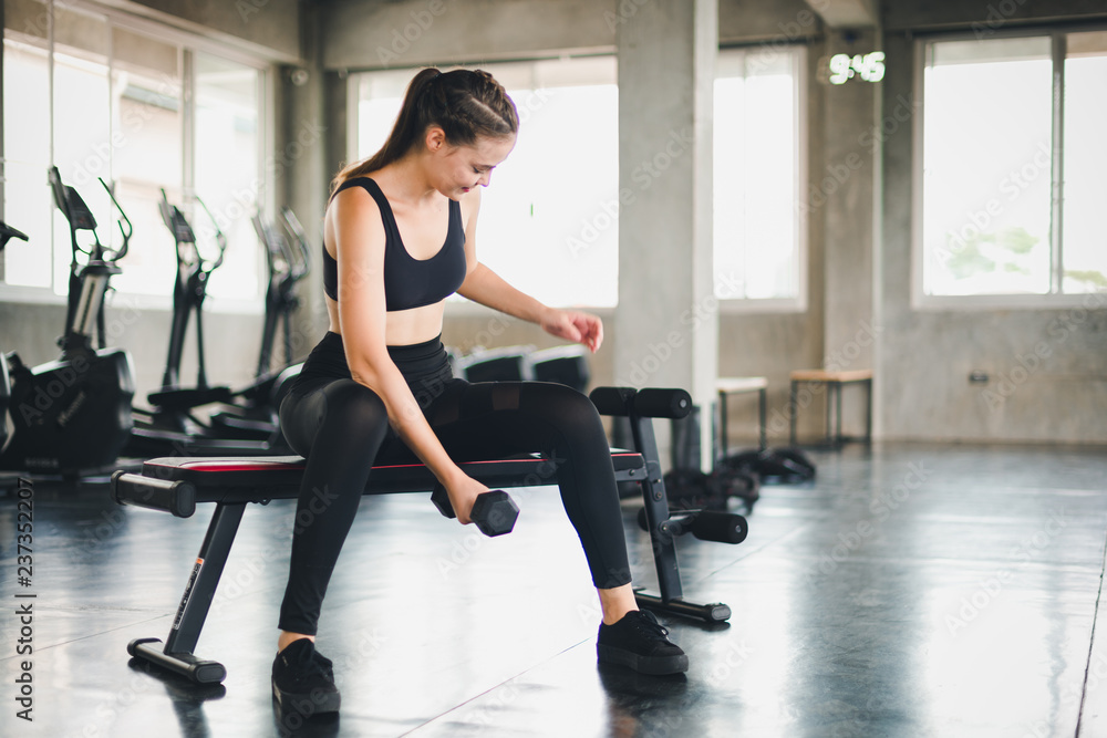 Beautiful girl caucasian is exercising with lifting dumbbell in the gym. Female athletes play a healthy training session. Beautiful girl caucasian is exercising with lifting dumbbell in the gym. Female athletes play a healthy training session.