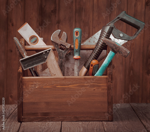 grungy old tools on a wooden background front view.