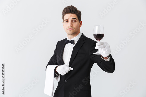 Handsome young waiter wearing tuxedo