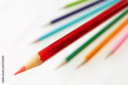 BRIGHT RED COLOURED PENCIL WITH OTHER PENCILS IN BACKGROUND