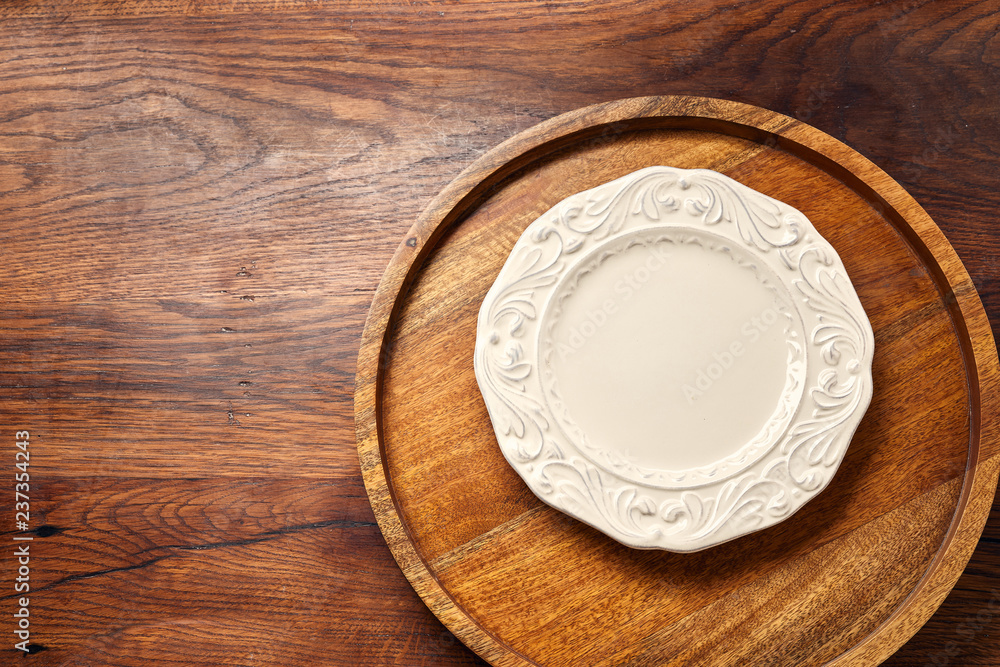 Empty white blank plate on wooden background with copy space. Top view. Empty white blank plate on wooden background with copy space. Top view.
