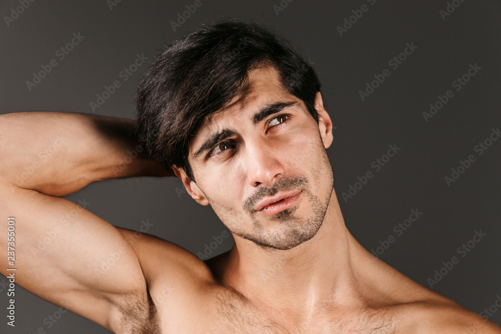 Handsome thoughtful serious young smiling man posing isolated over dark wall background. Handsome thoughtful serious young smiling man posing isolated over dark wall background.
